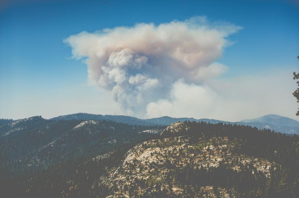 Free Image of Large Plume of Smoke Rising From Mountain Top 