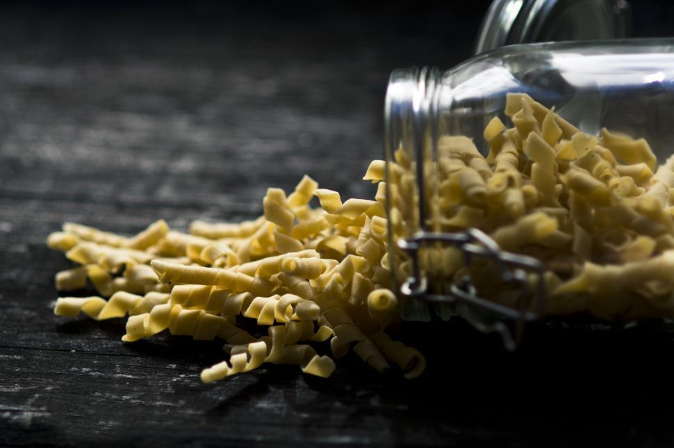 Free Image of Glass Jar Filled With Yellow Pasta on Wooden Table 