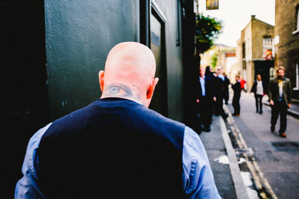 Free Image of Bald Man Walking Down Street 