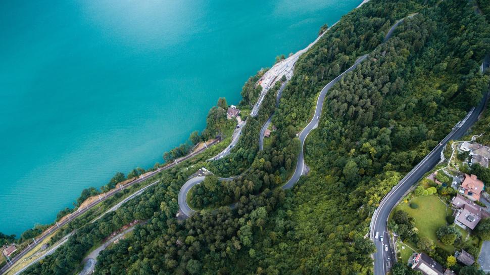 Free Image of Aerial View of Winding Road Alongside Body of Water 