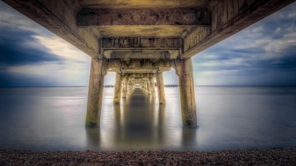 Free Image of The Underside of a Pier on a Cloudy Day 