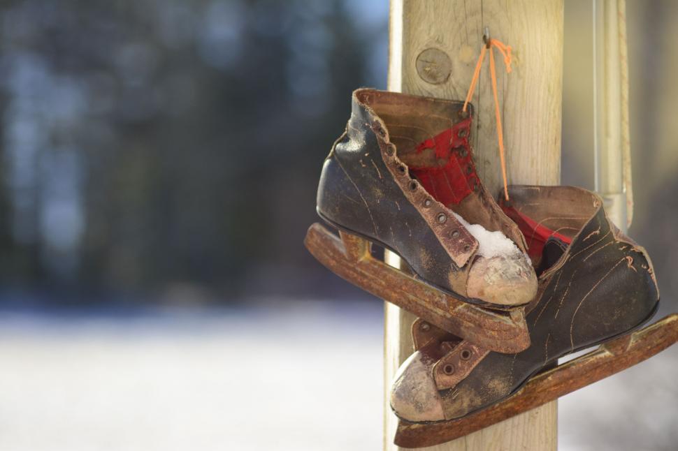 Free Image of A Pair of Old Worn Shoes Hanging on a Door 