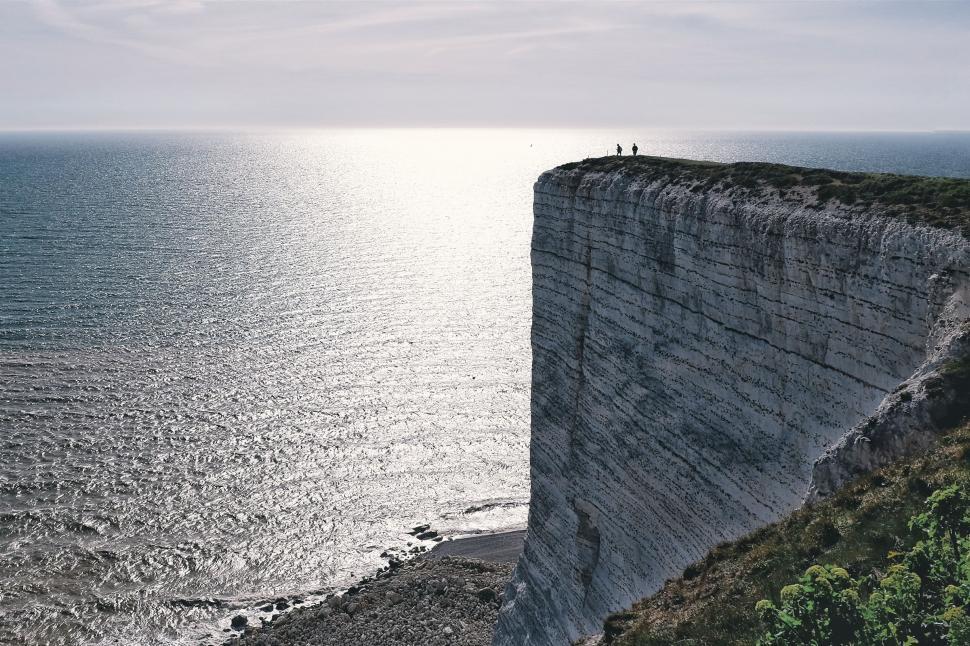 Free Image of Person Standing on Edge of Cliff Overlooking Ocean 