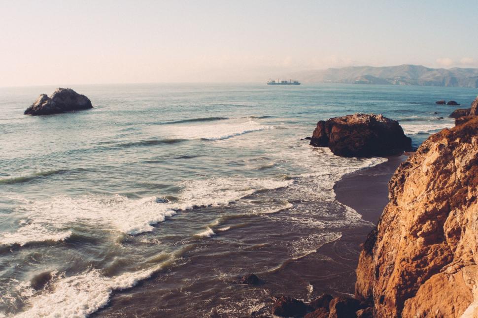Free Image of A Glimpse of the Ocean From a Rocky Cliff 