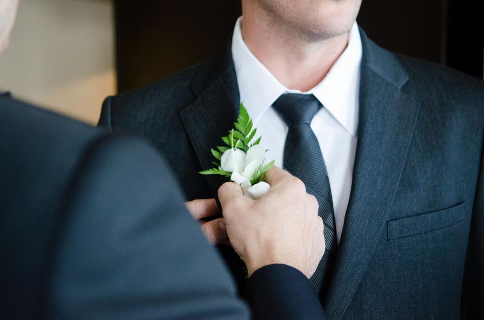 Free Image of Man Adjusts Boutonniere on Suit 