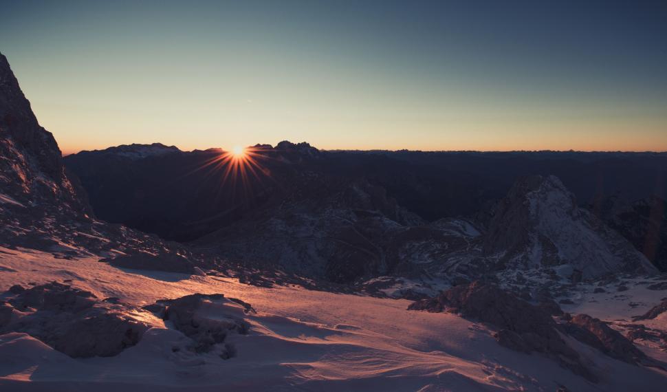 Free Image of Sun Setting Over Snowy Mountain 