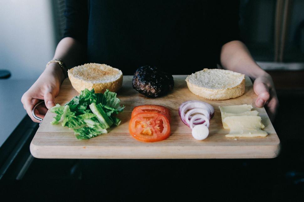 Free Image of Person Holding Cutting Board With Variety of Food 