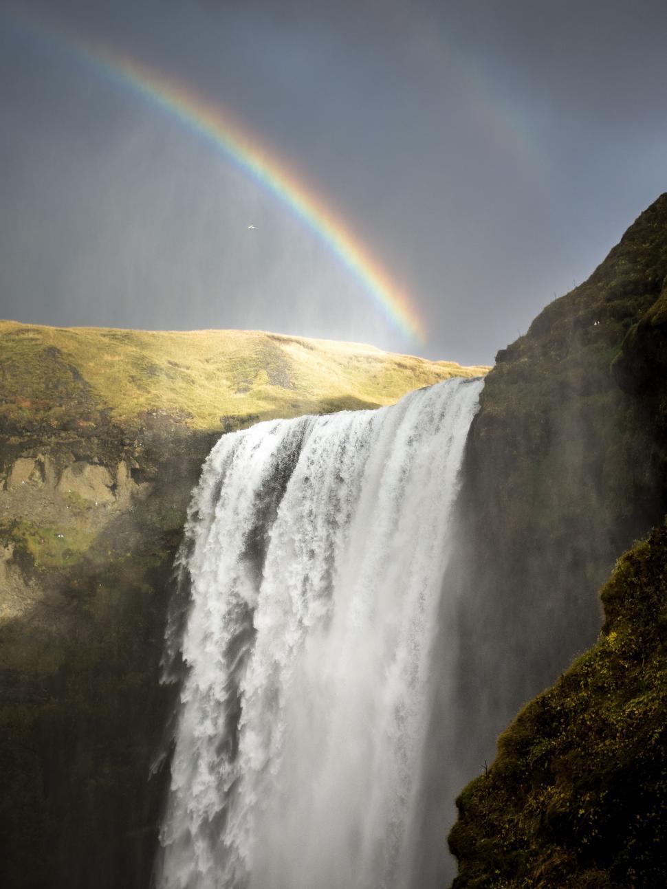 Free Image of Majestic Waterfall With Rainbow in Background 