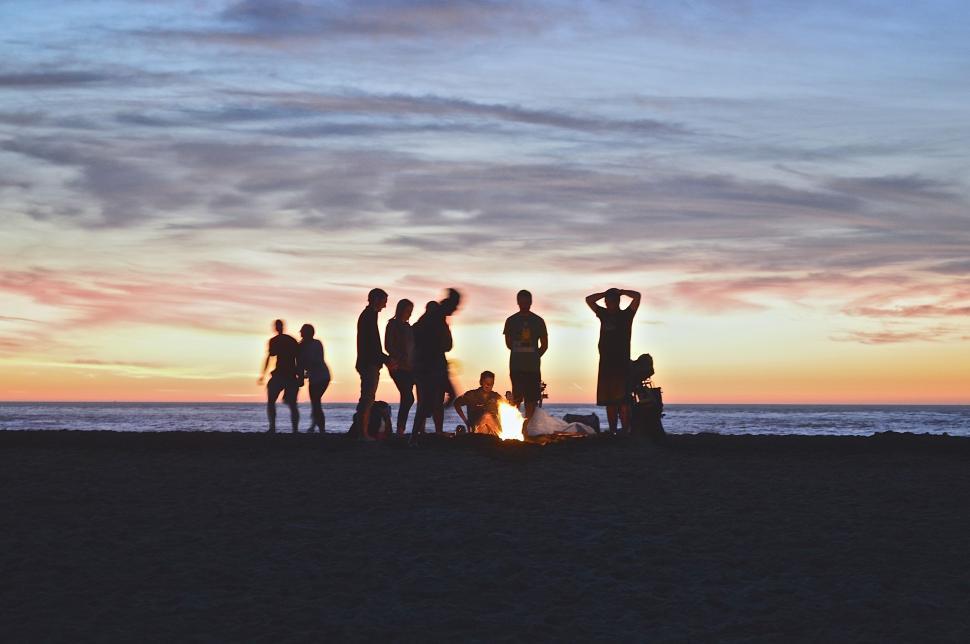 Free Image of Group of People Standing Around a Fire on a Beach 