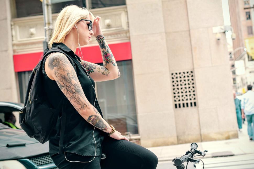 Free Image of Woman With Tattoos Sitting on a Bike 