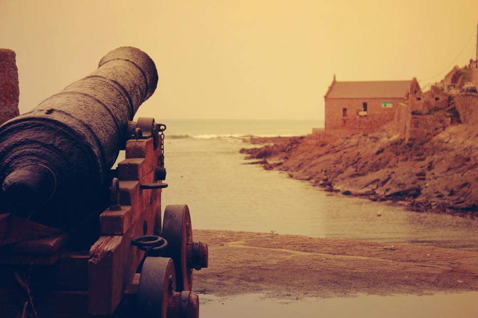 Free Image of Cannon on Wooden Rail by Water 