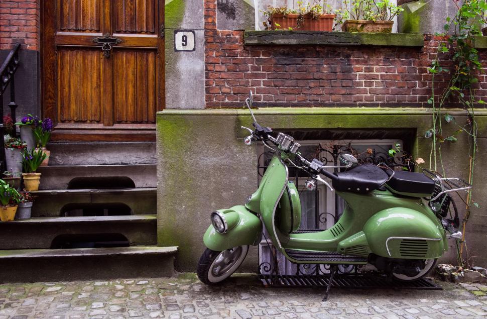 Free Image of Green Scooter Parked in Front of Building 