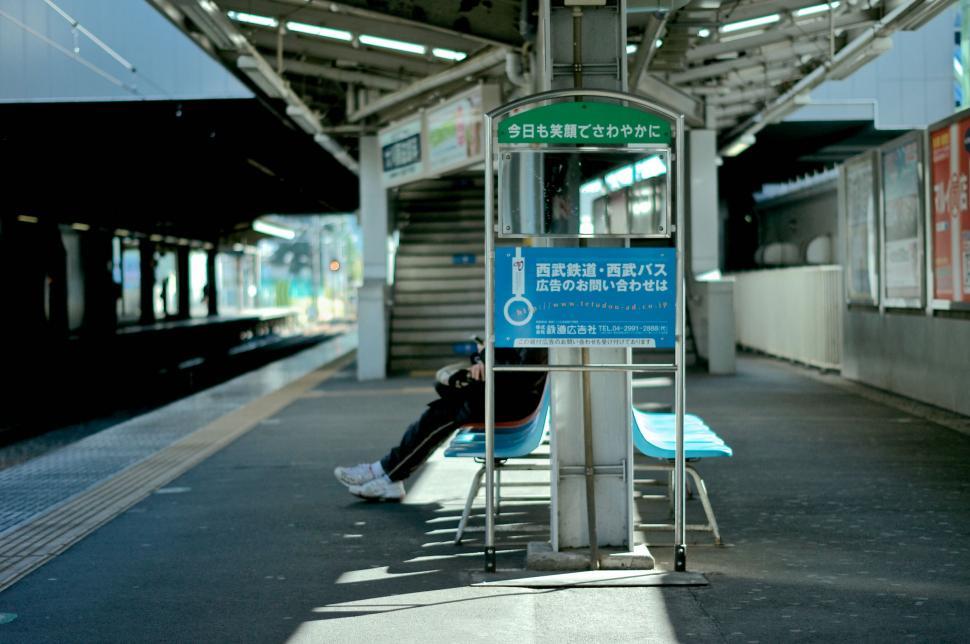 Free Image of Person Sitting on Bench at Train Station 