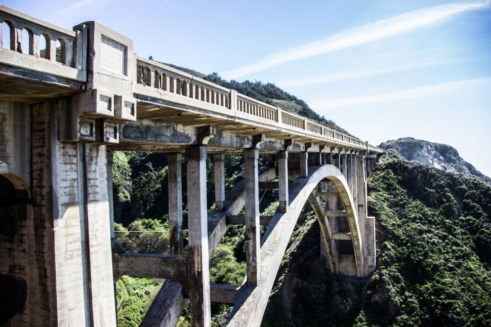 Free Image of Large Bridge Over Mountain With Sky Background 
