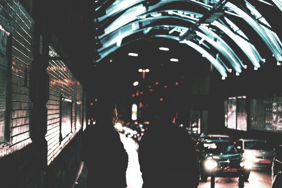 Free Image of Couple Walking Down City Street at Night 