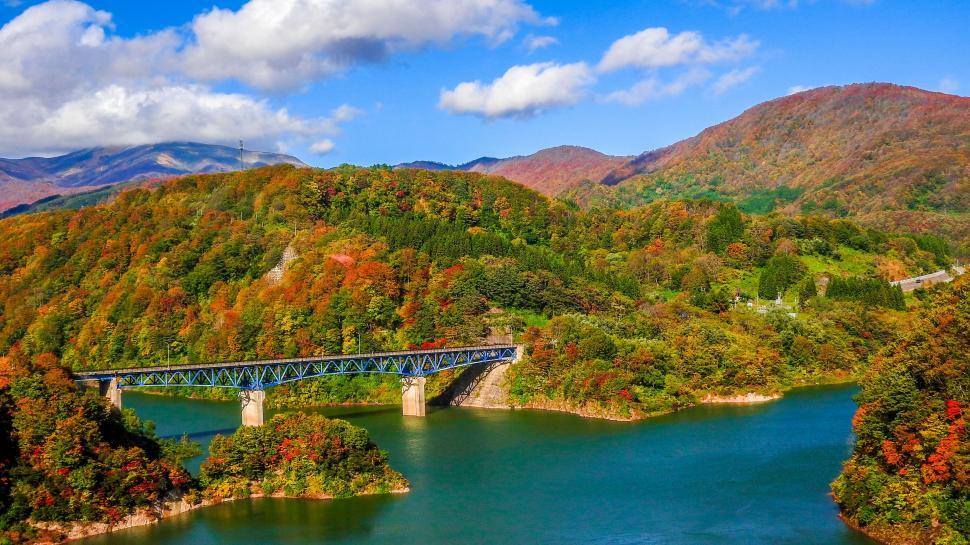 Free Image of Bridge Crossing Over Water Surrounded by Mountains 