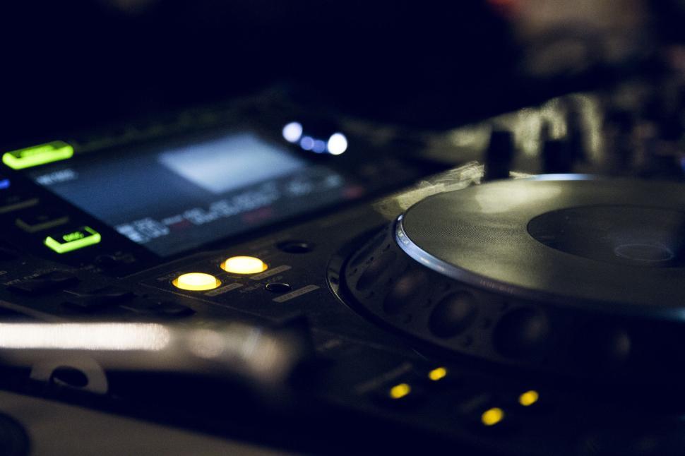 Free Image of Close Up of DJ Controller With Cell Phone in Background 