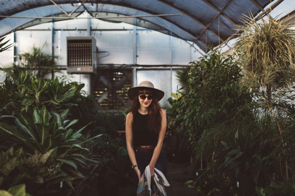 Free Image of Woman Standing in Greenhouse Holding Shovel 