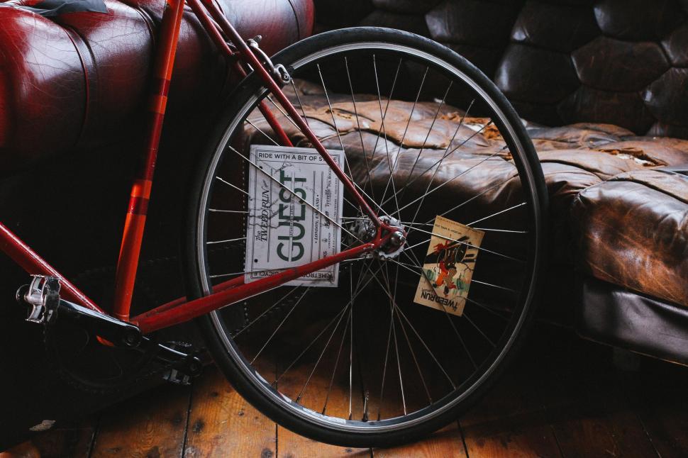 Free Image of Red Bike Parked Next to Leather Couch 