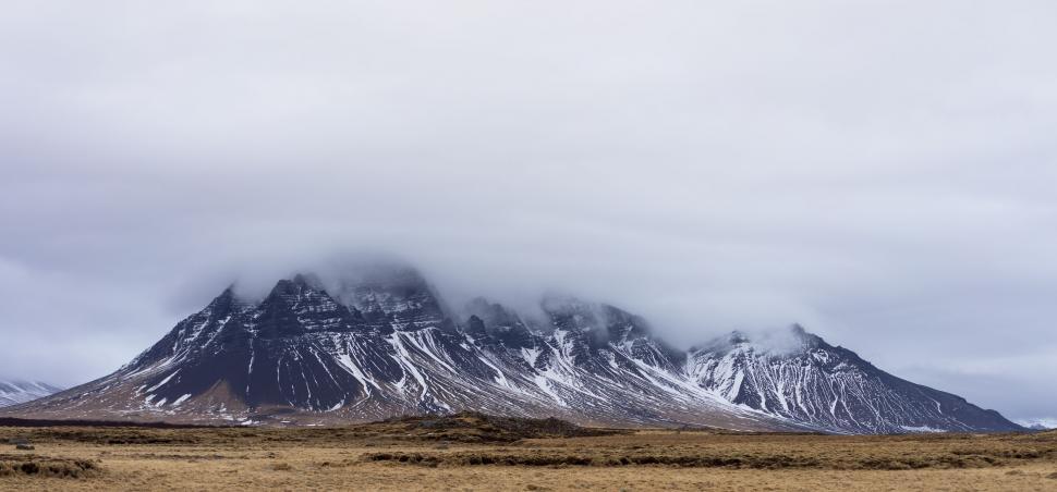 Free Image of Majestic Mountain Covered in Snow and Clouds 