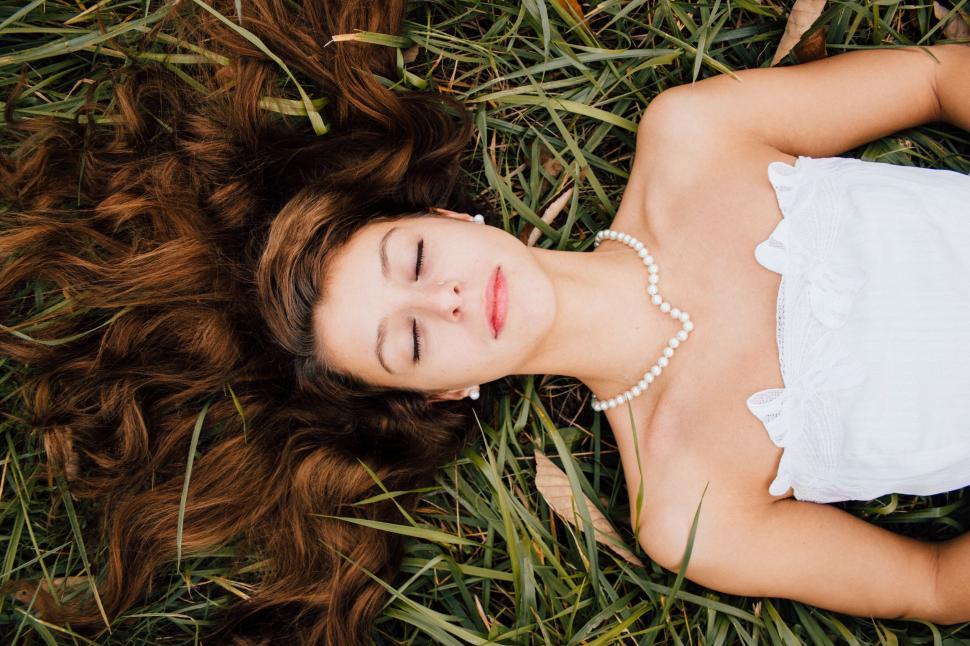 Free Image of Woman Laying in Grass With Eyes Closed 