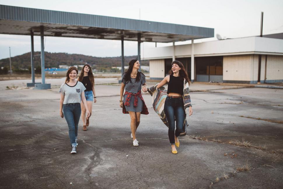 Free Image of Group of Young Women Walking Across Parking Lot 