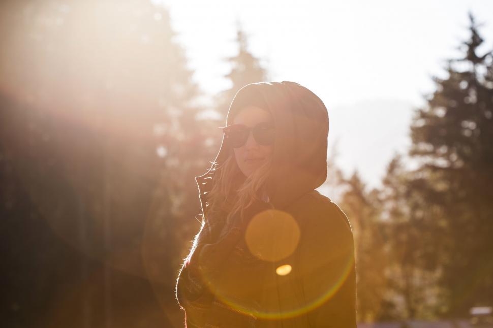 Free Image of Woman Standing in Sun Talking on Cell Phone 