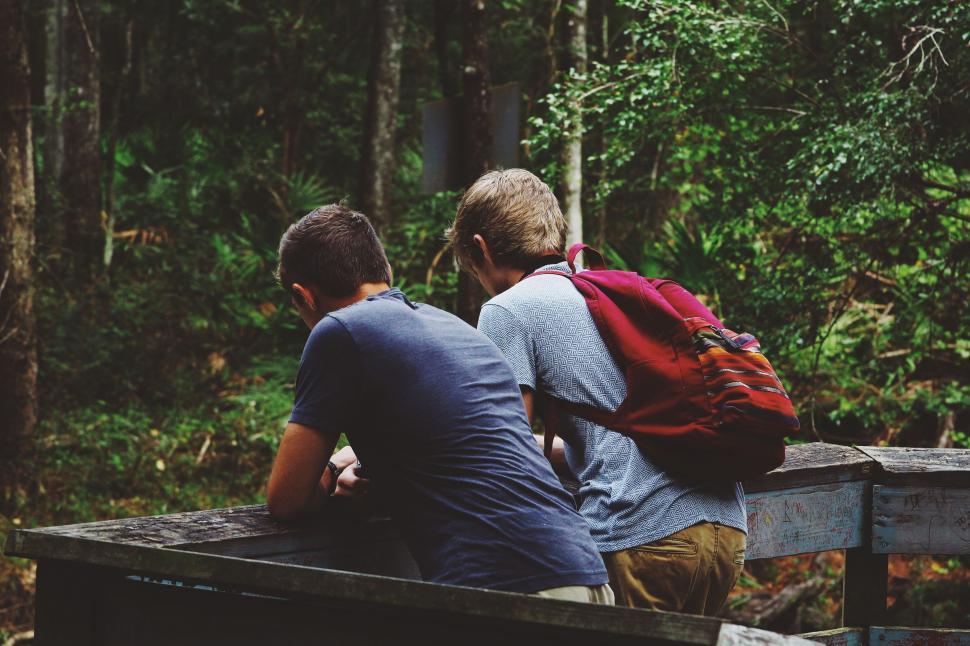 Free Image of Two Men Sitting on a Bench in the Woods 