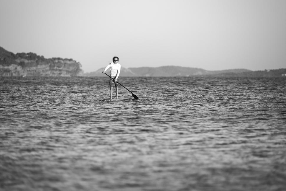 Free Image of Man Standing on Surfboard in Middle of Ocean 