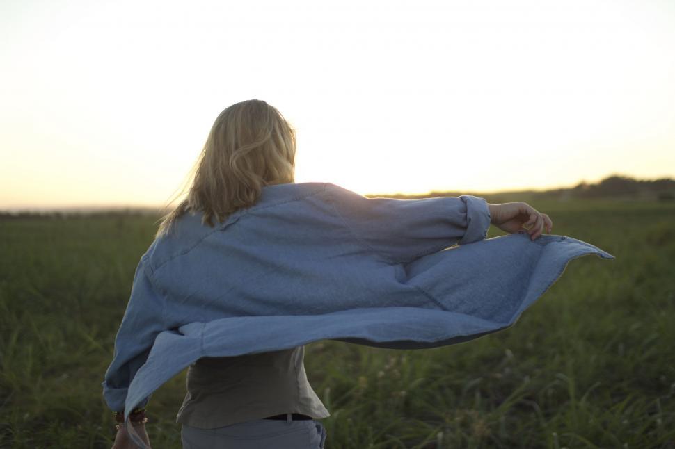 Free Image of Woman Standing in Field With Blue Blanket 