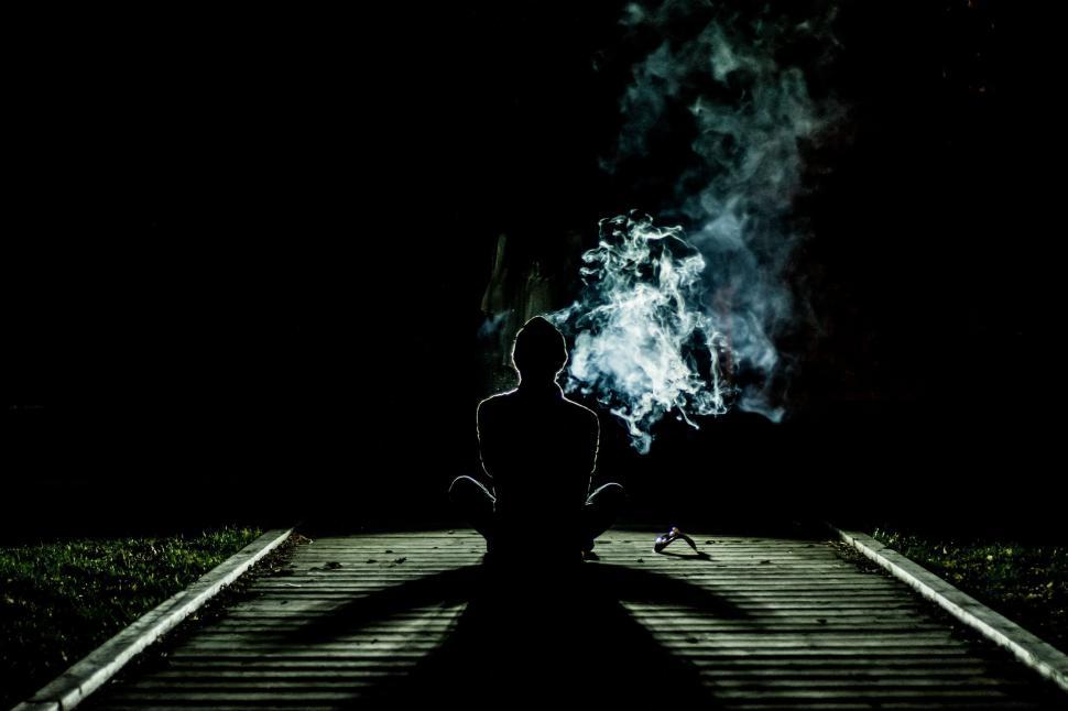 Free Image of Person Sitting on Train Track in the Dark 