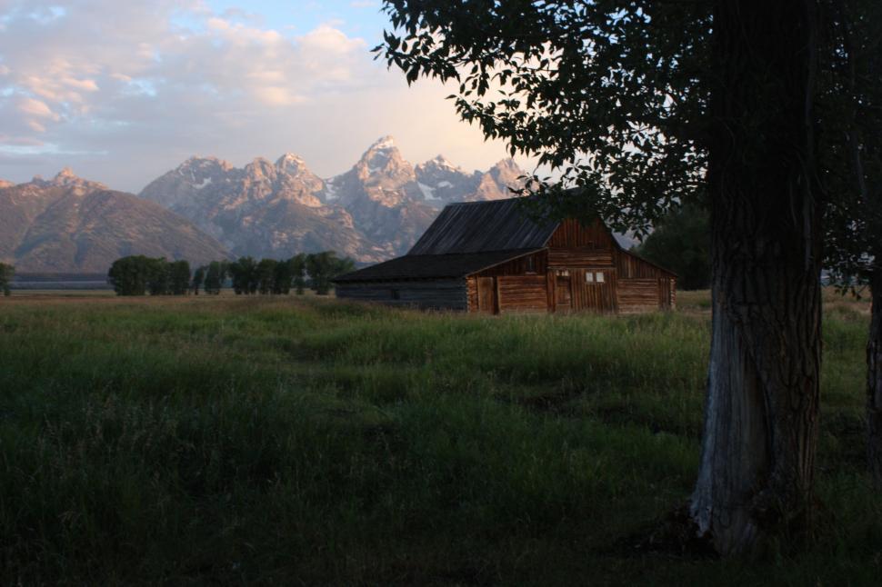 Free Image of Barn in a Field With Mountains in the Background 
