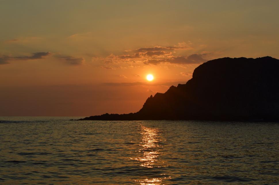 Free Image of Sun Setting Over Small Island in Ocean 