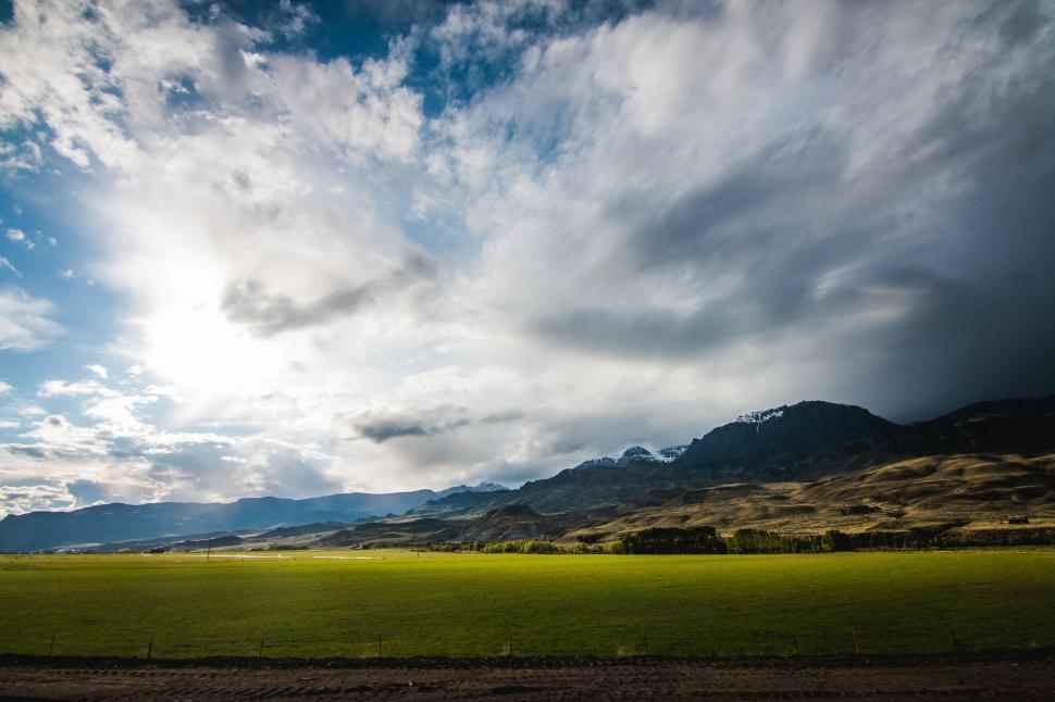 Free Image of Green Field With Mountains in the Background 