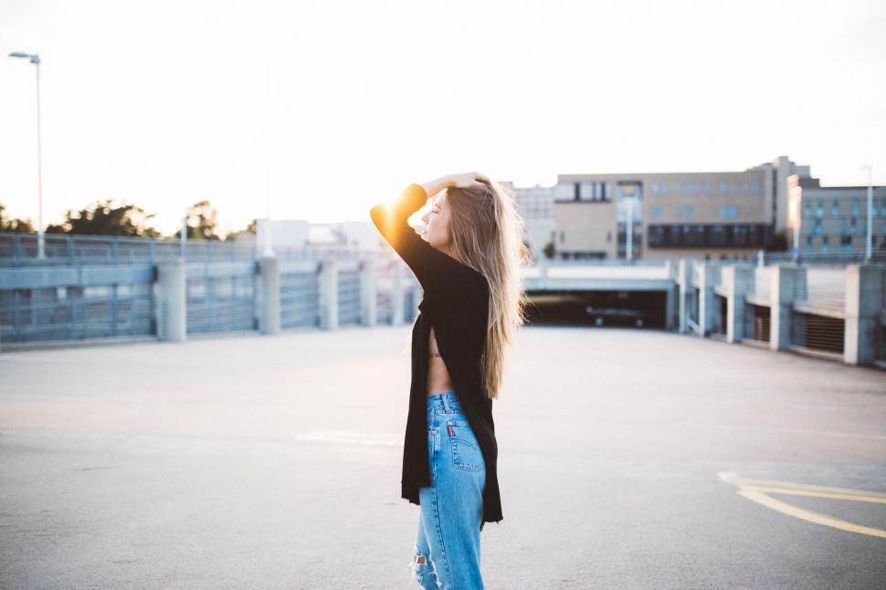 Free Image of Woman With Long Blonde Hair Standing in Parking Lot 