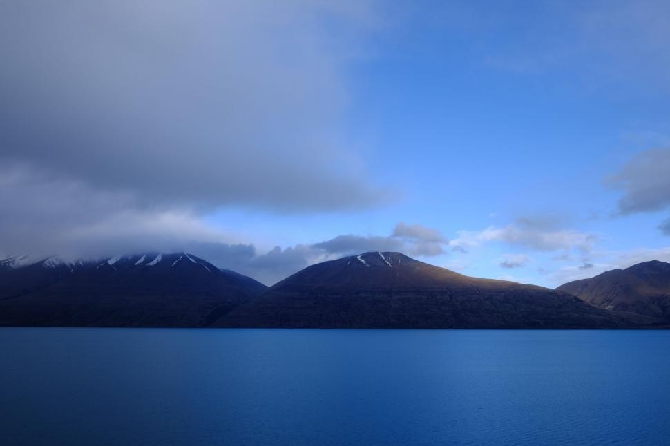 Free Image of Mountain-Encircled Lake Under Cloudy Sky 