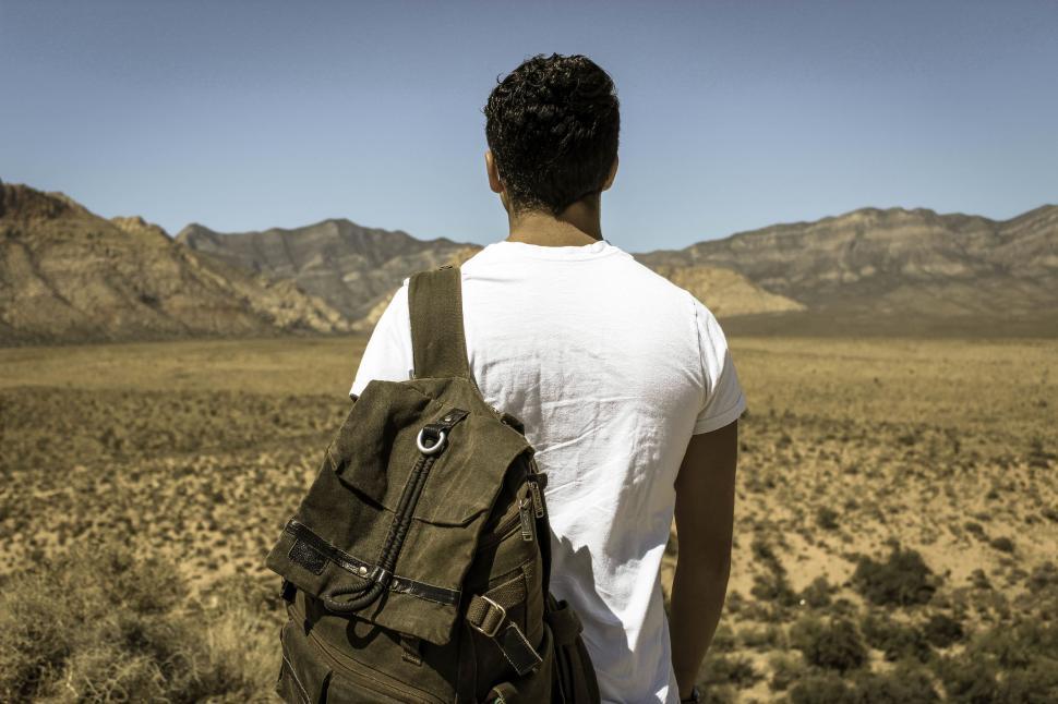 Free Image of Man Walking Through Desert With Backpack 