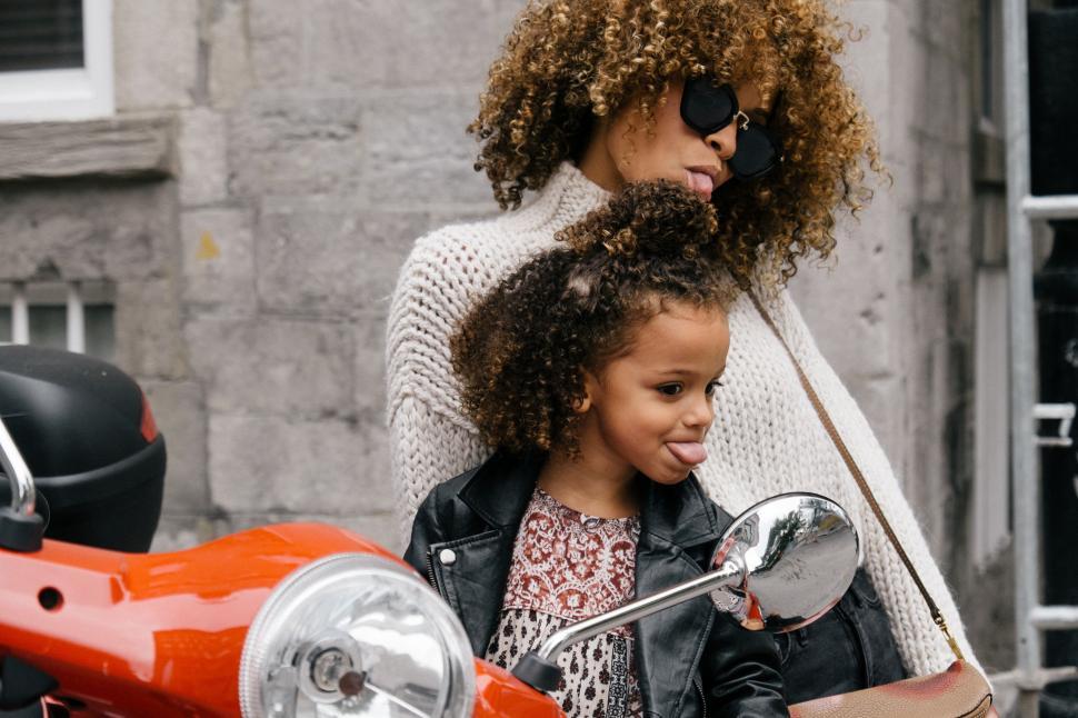 Free Image of Woman and Little Girl Sitting on Motorcycle 