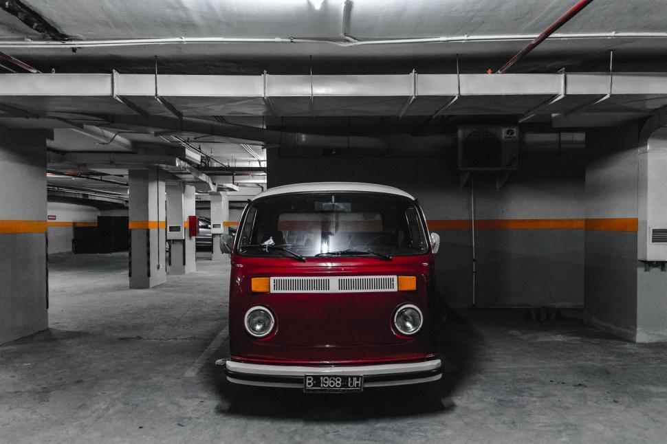 Free Image of Red and White Van Parked in a Parking Garage 