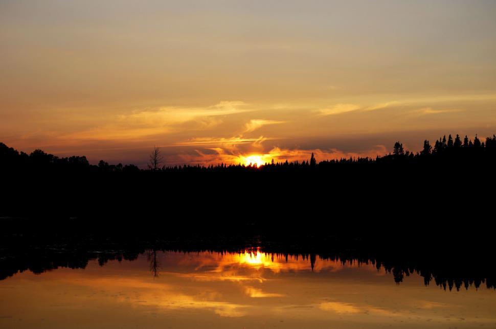 Free Image of Sun Setting Over Lake With Trees 