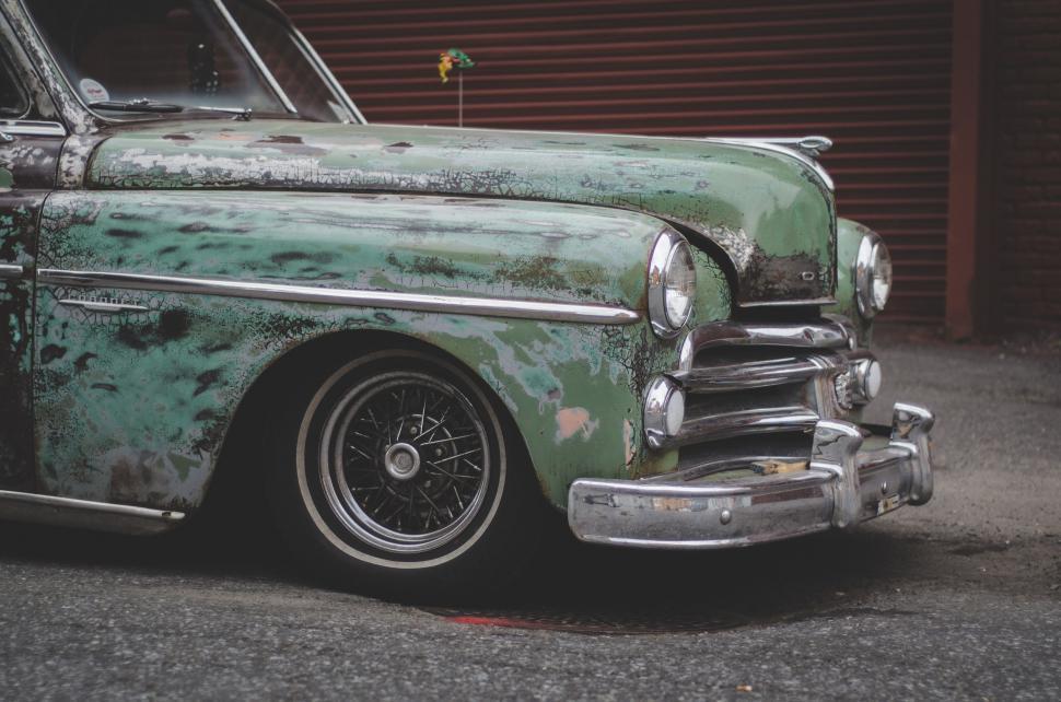 Free Image of Old Green Car Parked in Front of Building 