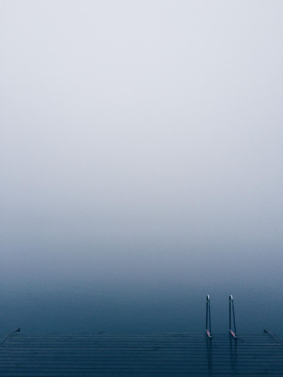 Free Image of Foggy Day at a Pier With Two Poles 