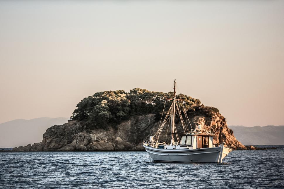 Free Image of Boat Sailing Near Small Island 