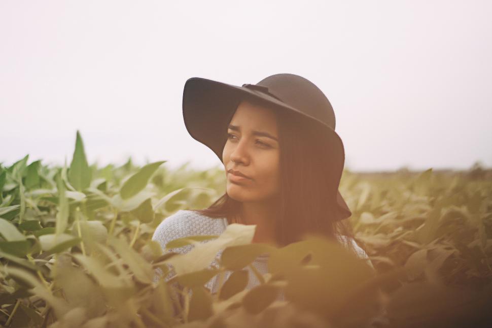 Free Image of Woman Wearing Hat Sitting in Field 