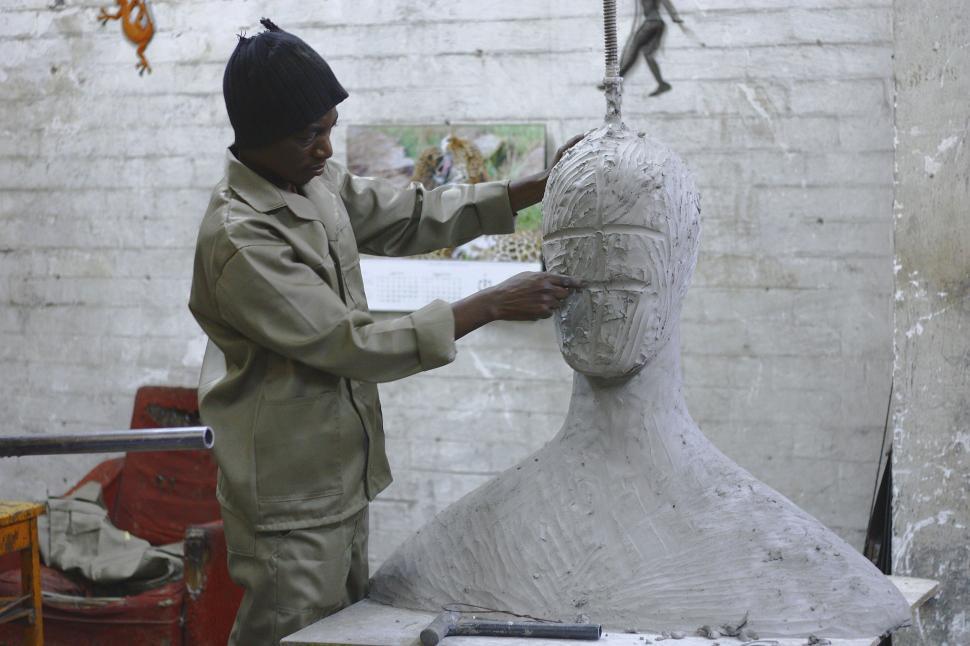 Free Image of Man Working on Sculpture of Womans Head 