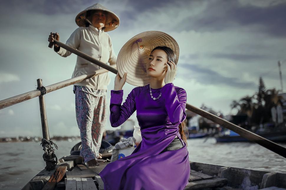 Free Image of Woman in Purple Dress and Man in White Hat on Boat 