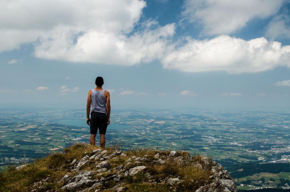 Free Image of Person Standing on Top of Hill Looking at Sky 