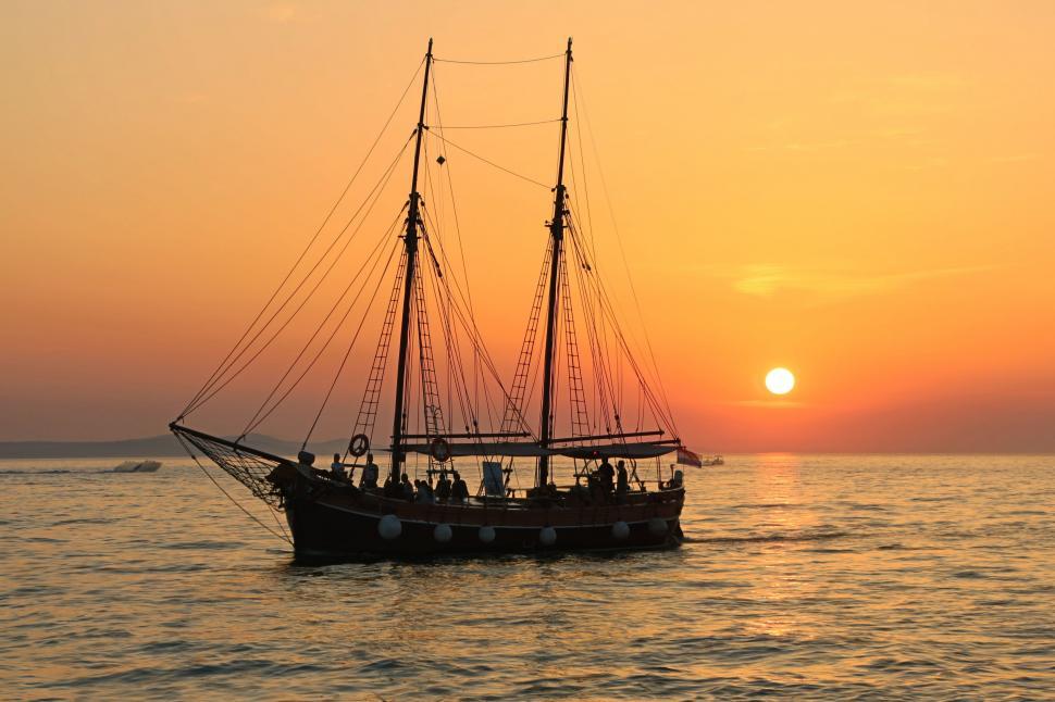 Free Image of Boat Sailing in Ocean at Sunset 