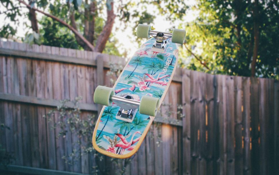 Free Image of Skateboard Soaring Over Fence 