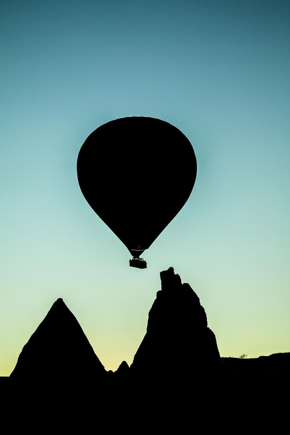 Free Image of Hot Air Balloon Flying Over Mountain Range 